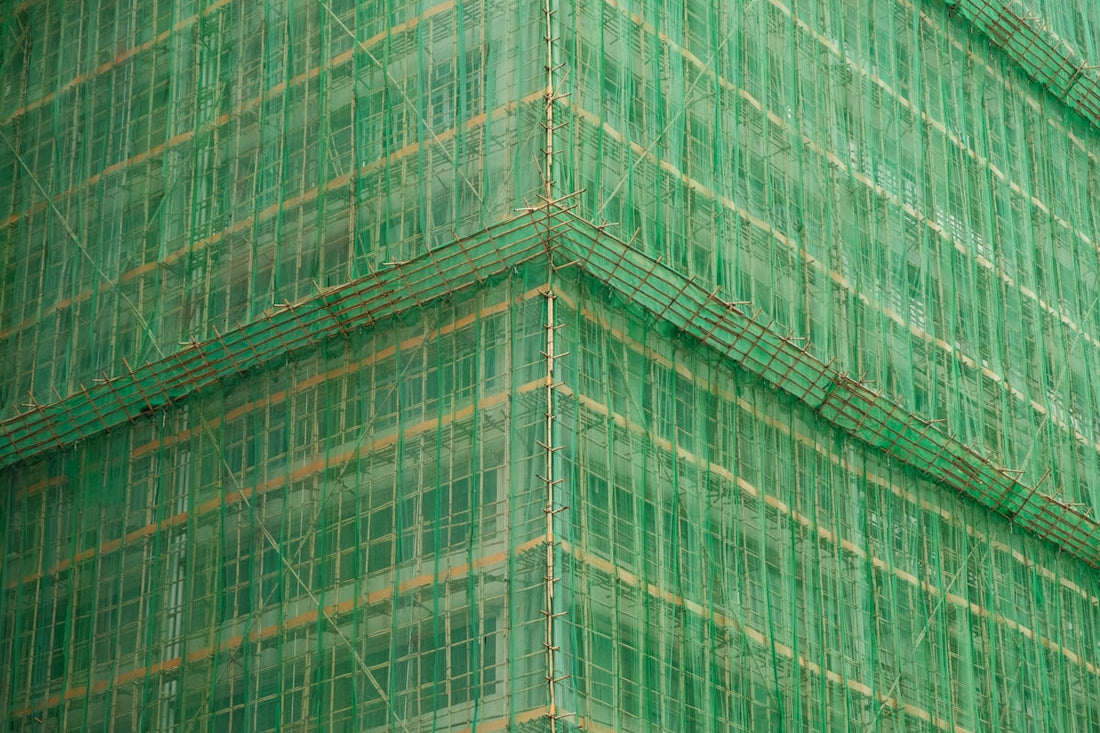 A tall green building with lots of windows